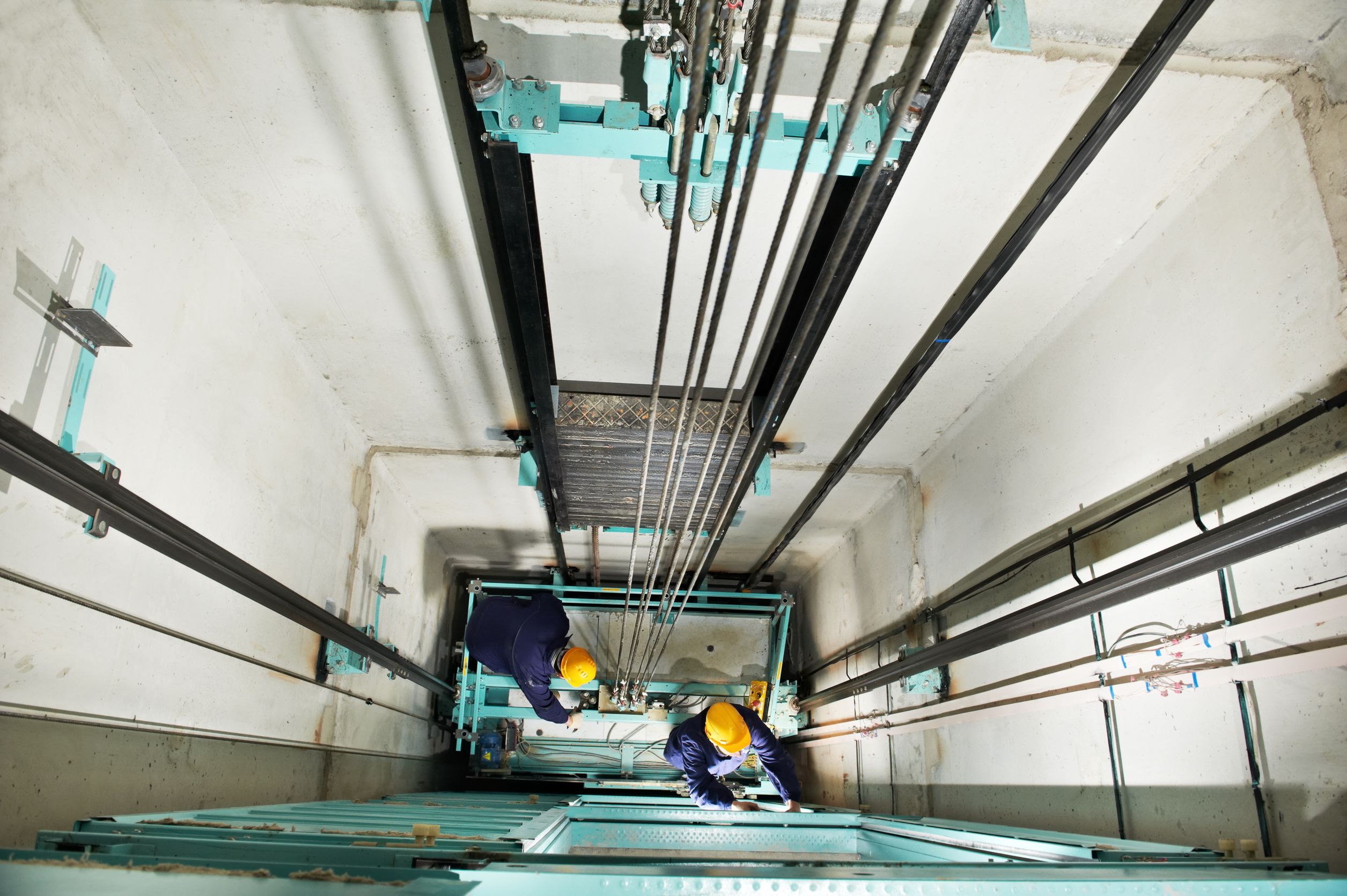 13701384_l-machinists-adjusting-lift-in-elevator-hoistway